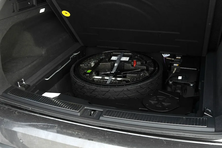 A spare tire in under the trunk liner in an automobile A spare tire in under the trunk liner in an automobile