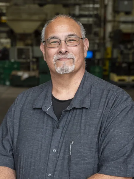 Gary Six - Engineering Manager Soundwich's Engineering Manager is Gary Six. Gary has short salt-and-pepper hair, goatee and mustache. He is wearing a short sleeved dark grey button down over a black t-shirt and rectangular eyeglasses.